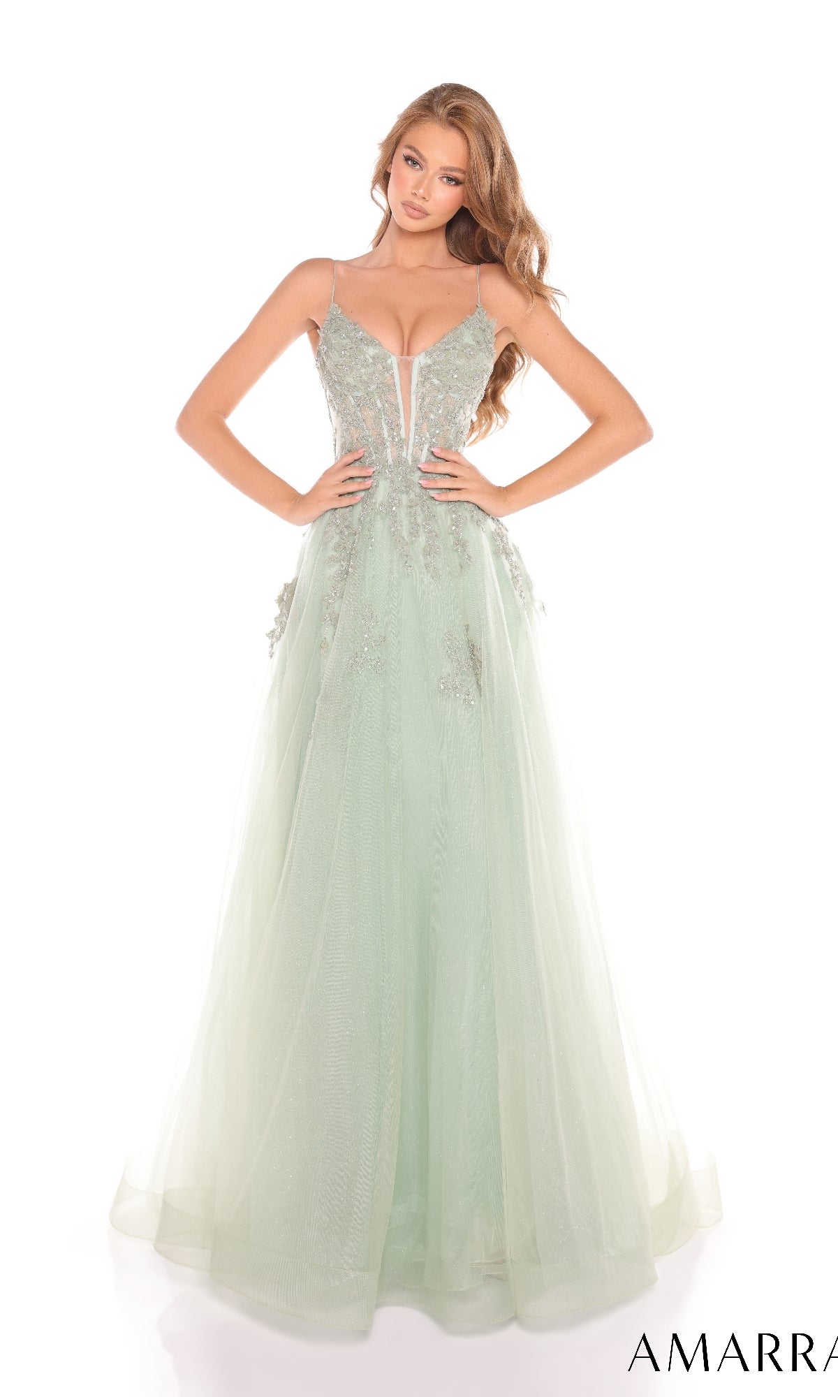 A woman poses against a white background in the Amarra 88253, a light green long prom dress with thin straps and delicate floral embroidery.